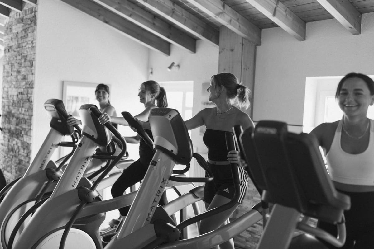 Vier Frauen lachen beim Training auf den Crosstrainern im TNT Fitness